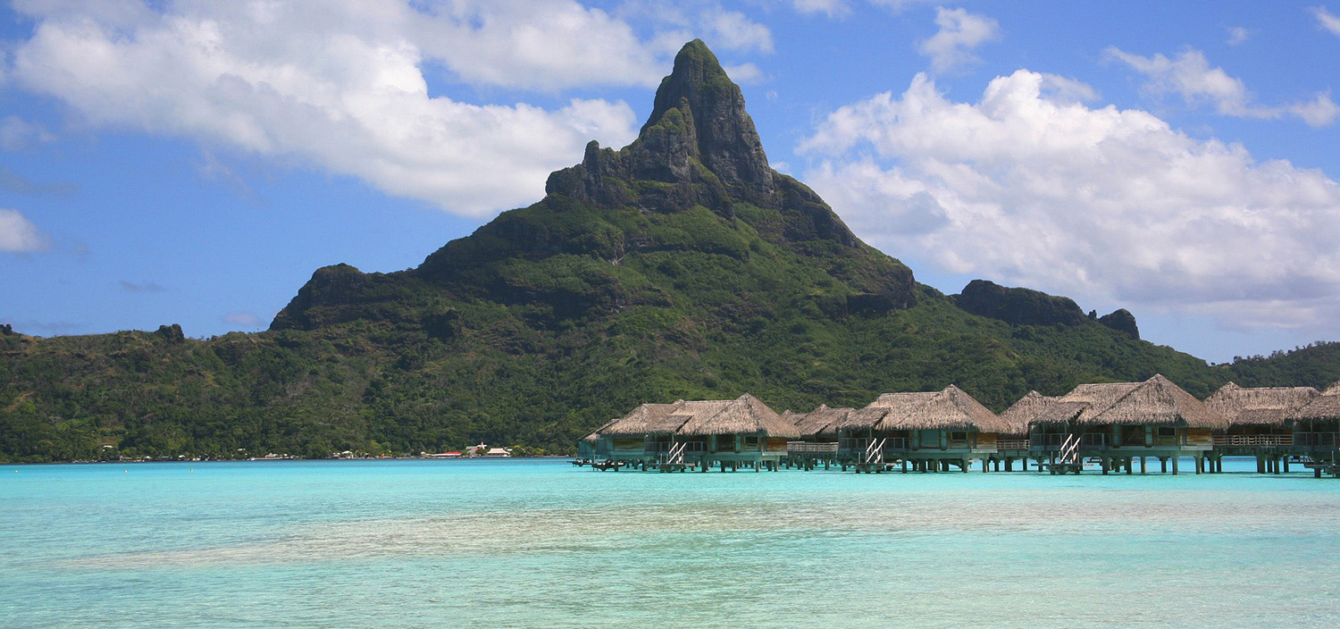 French Polynesia yacht charter huts over the water and moutain